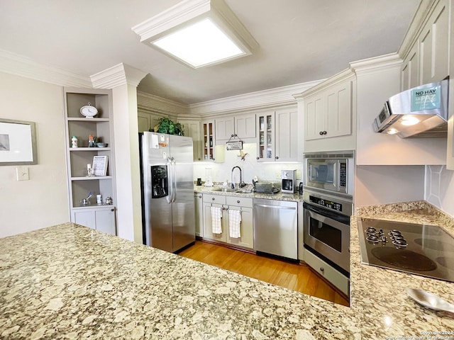 kitchen featuring sink, white cabinets, light hardwood / wood-style flooring, stainless steel appliances, and wall chimney range hood