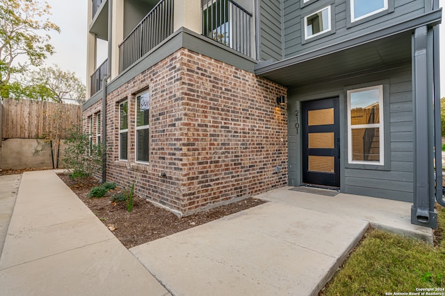 entrance to property featuring a patio and a balcony