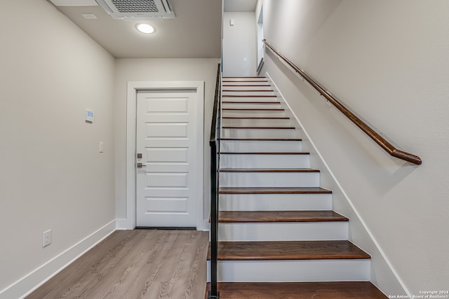 staircase with hardwood / wood-style flooring