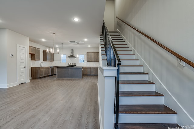 staircase featuring wood-type flooring and sink