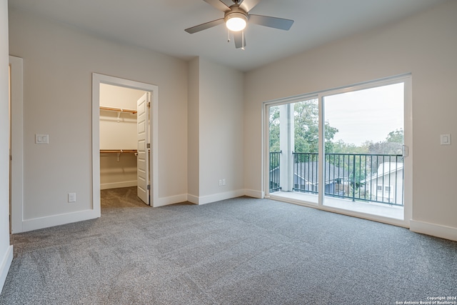 unfurnished bedroom featuring access to exterior, a spacious closet, ceiling fan, light colored carpet, and a closet