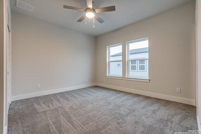 carpeted spare room featuring ceiling fan