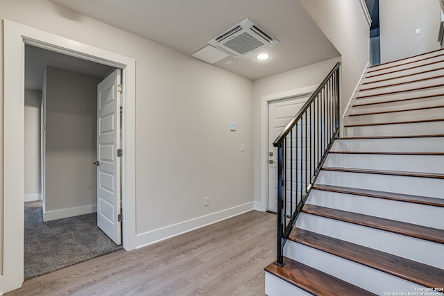 staircase with hardwood / wood-style flooring