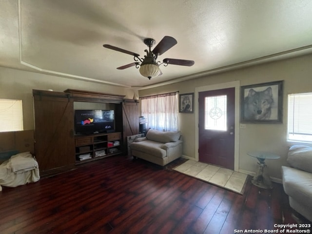 tiled living room with plenty of natural light and ceiling fan