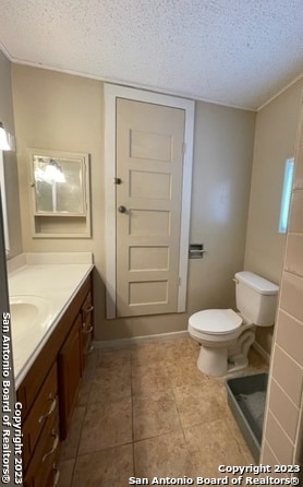 bathroom with vanity, toilet, and a textured ceiling