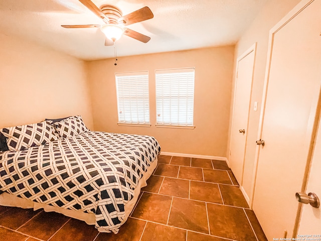 tiled bedroom featuring ceiling fan