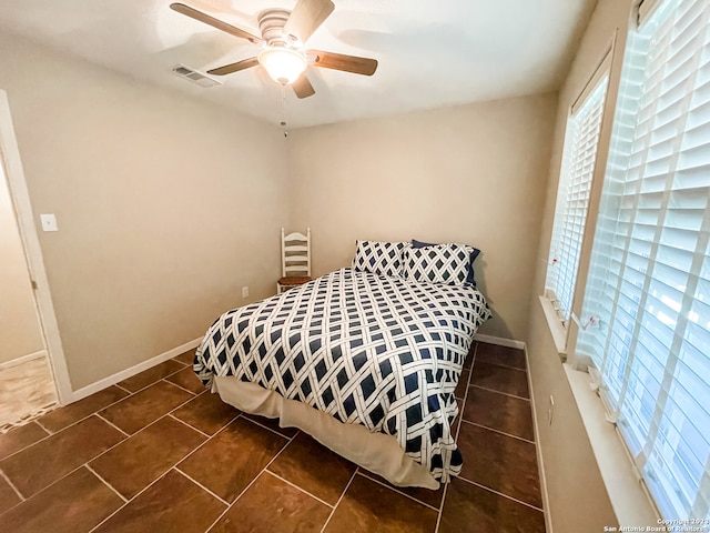 tiled bedroom featuring ceiling fan