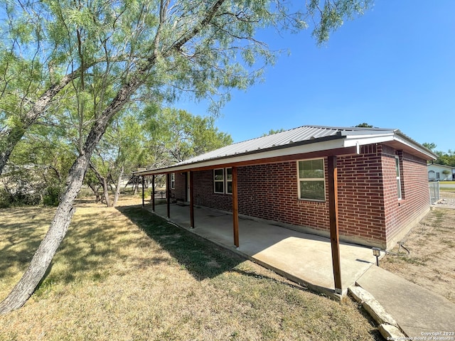 back of house with a lawn and a patio area