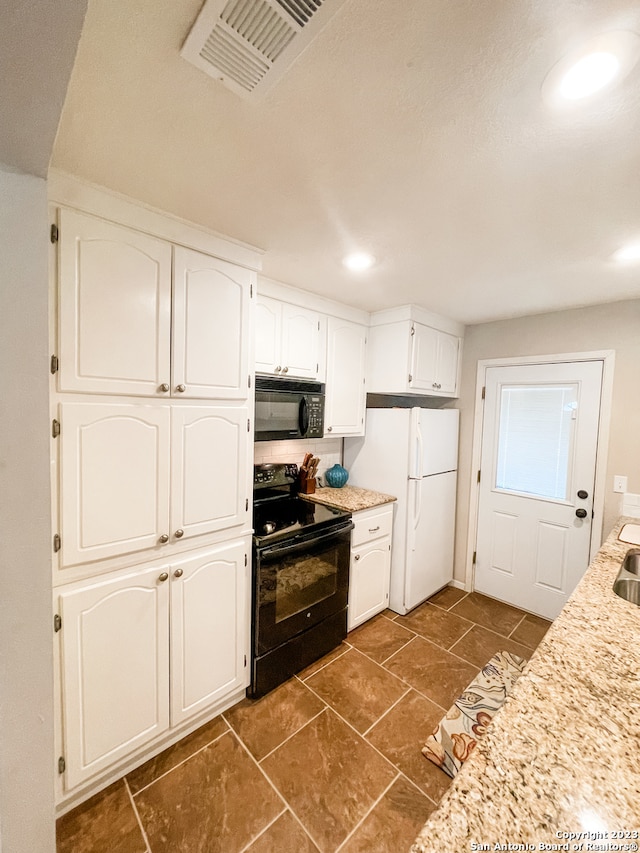 kitchen featuring dark tile floors, white cabinetry, and black appliances