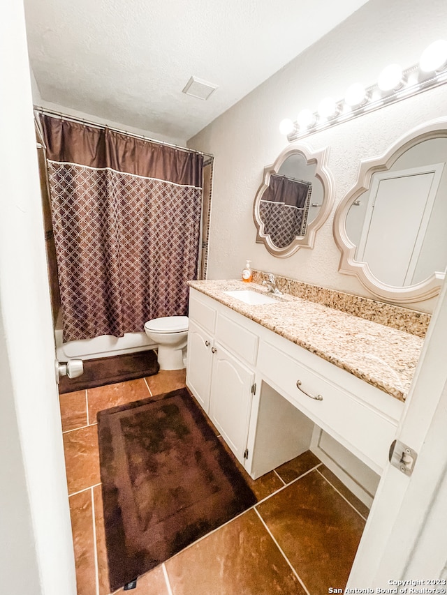 bathroom featuring tile floors, vanity with extensive cabinet space, and toilet