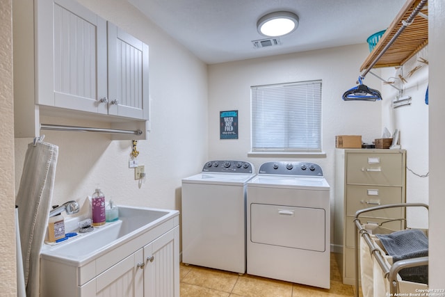 laundry room with washing machine and dryer, cabinets, sink, and light tile floors