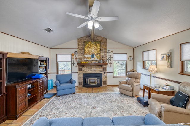 tiled living room with brick wall, vaulted ceiling, ceiling fan, and a brick fireplace