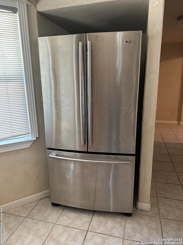 details with stainless steel fridge and light tile flooring