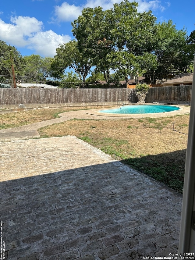 view of yard featuring a fenced in pool and a patio