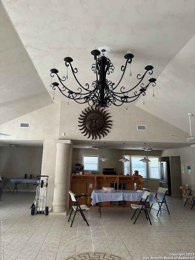 interior space featuring ornate columns, ceiling fan, light tile floors, and lofted ceiling