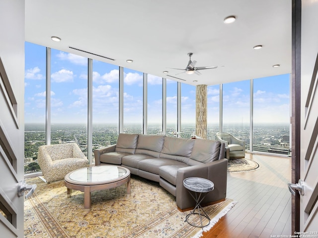 living room featuring expansive windows, light hardwood / wood-style floors, and ceiling fan