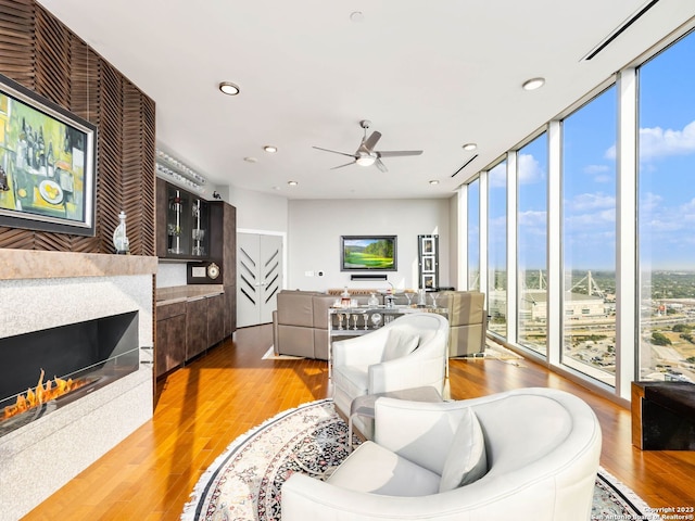 living room with ceiling fan, a wealth of natural light, and light hardwood / wood-style floors