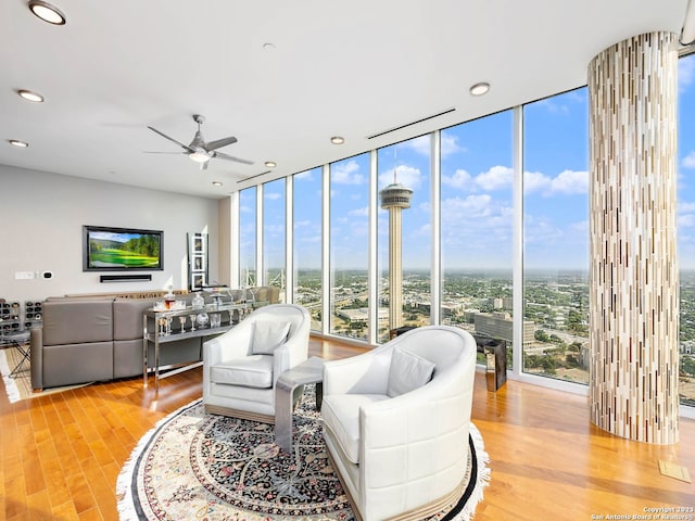 living room with floor to ceiling windows, light hardwood / wood-style floors, and ceiling fan