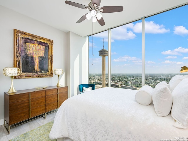 bedroom featuring a wall of windows, ceiling fan, and multiple windows