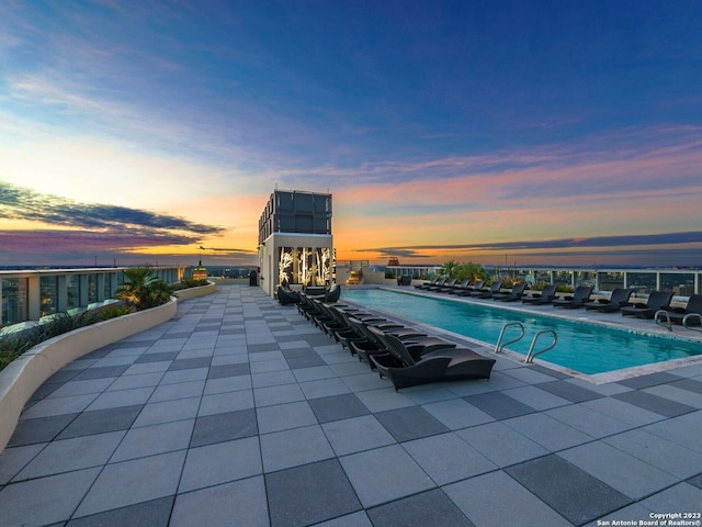 pool at dusk with a patio