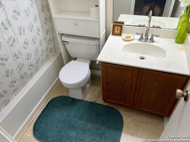 full bathroom featuring toilet, tile flooring, shower / tub combo with curtain, and vanity