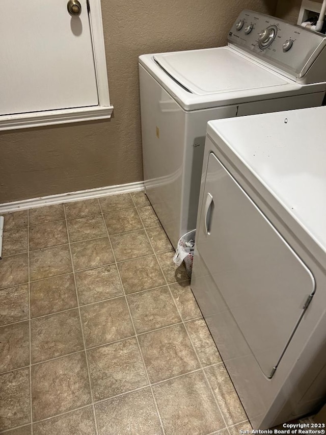 clothes washing area featuring tile floors and independent washer and dryer