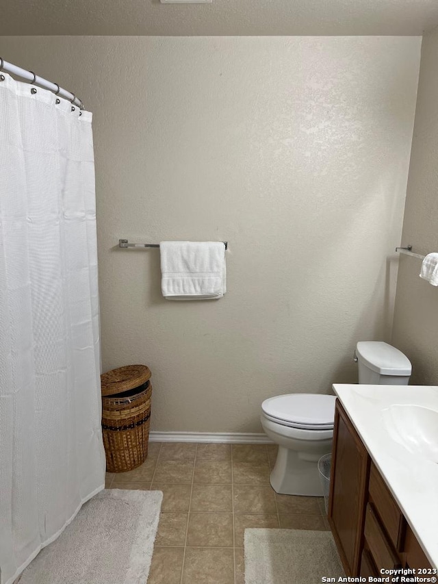 bathroom featuring tile floors, toilet, and vanity