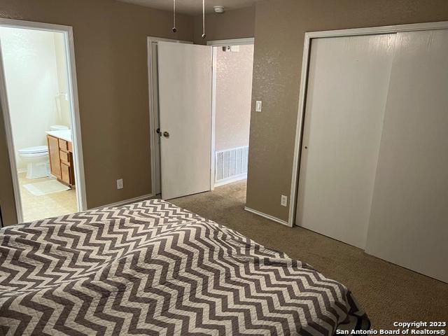 carpeted bedroom featuring connected bathroom