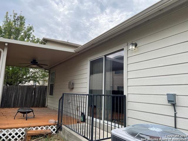 view of side of property with a deck, central AC, and ceiling fan