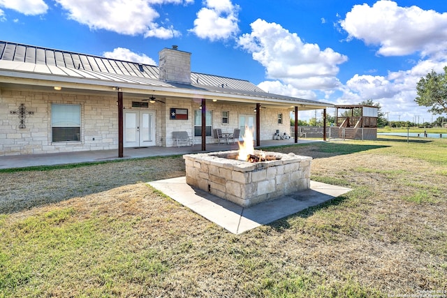 exterior space with a lawn, a patio, ceiling fan, and a fire pit