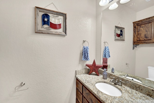 bathroom featuring toilet and vanity with extensive cabinet space