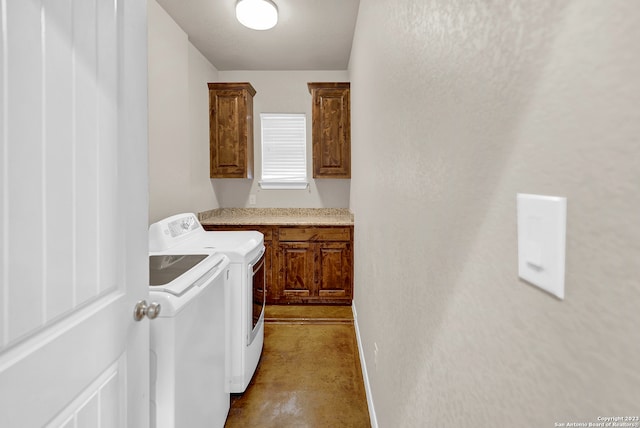 clothes washing area with cabinets and washer and clothes dryer