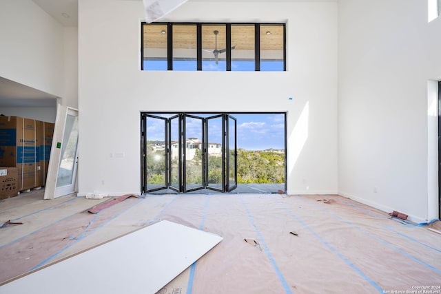 unfurnished living room with a towering ceiling