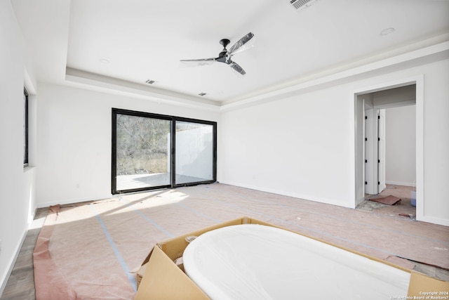 interior space featuring access to outside, ceiling fan, and a tray ceiling