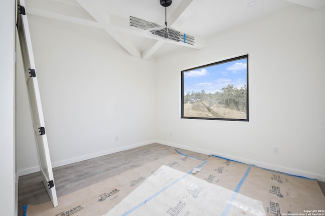 unfurnished room featuring beam ceiling and light hardwood / wood-style flooring