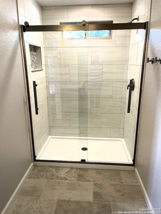 bathroom featuring a stall shower and baseboards