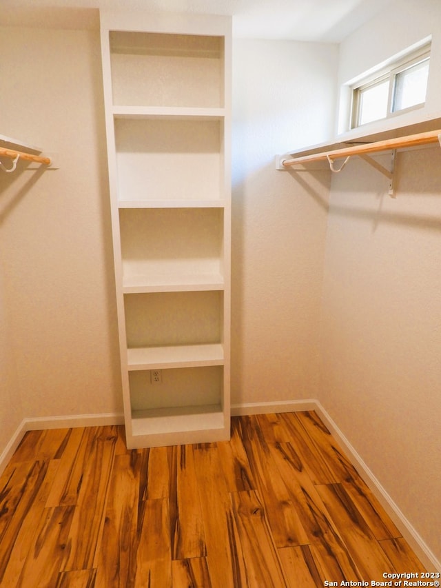 walk in closet with wood finished floors