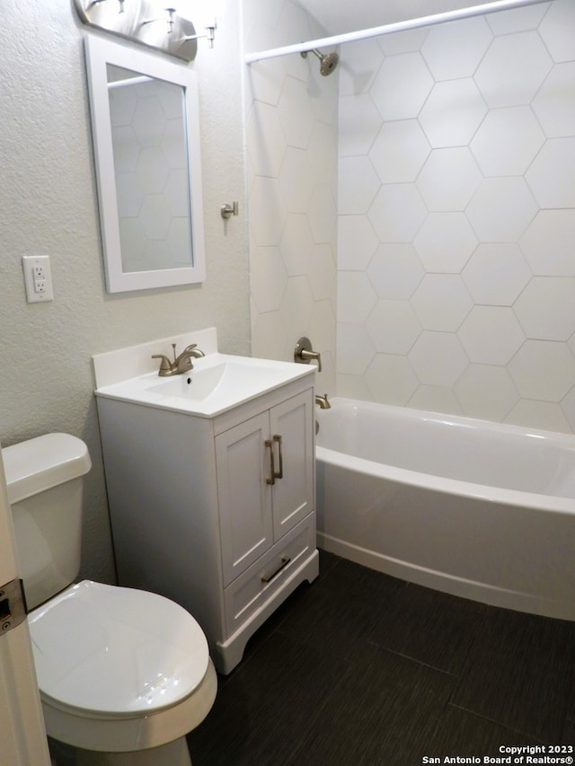 bathroom with bathtub / shower combination, a textured wall, vanity, and toilet