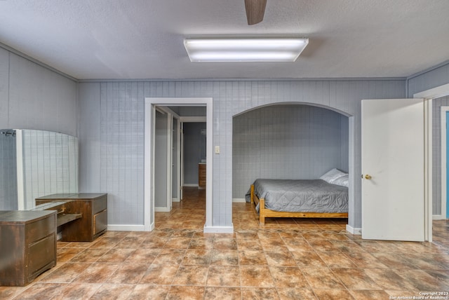 tiled bedroom featuring a textured ceiling and ceiling fan