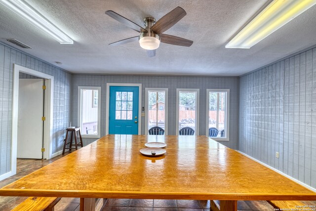 unfurnished dining area with a textured ceiling and ceiling fan