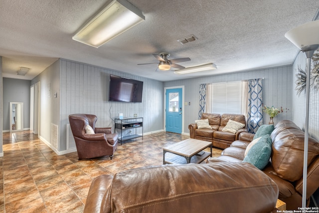 tiled living room featuring a textured ceiling and ceiling fan