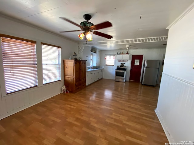 kitchen featuring plenty of natural light, hardwood / wood-style floors, ceiling fan, and appliances with stainless steel finishes