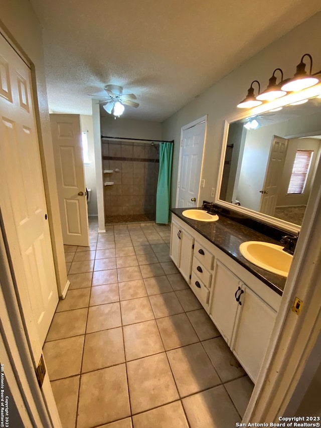 bathroom featuring double sink vanity, a textured ceiling, tile floors, and ceiling fan