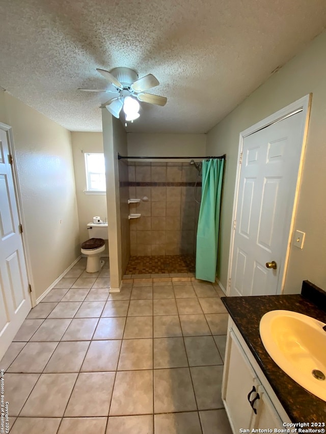 bathroom featuring a textured ceiling, vanity, ceiling fan, and tile flooring