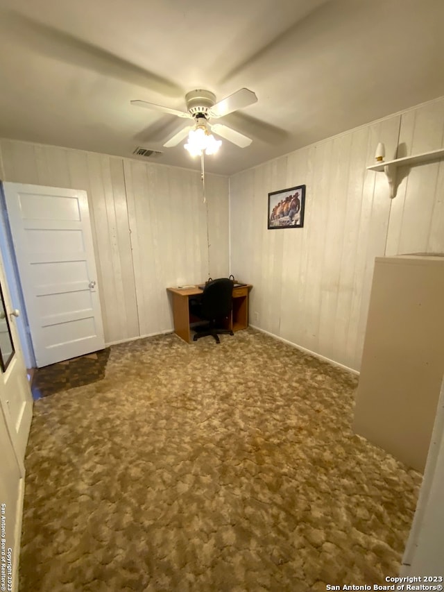 interior space featuring ceiling fan and dark colored carpet