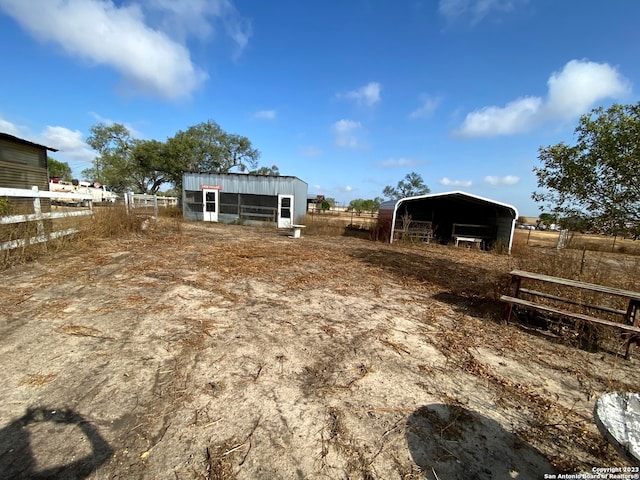 view of yard featuring a rural view and an outdoor structure