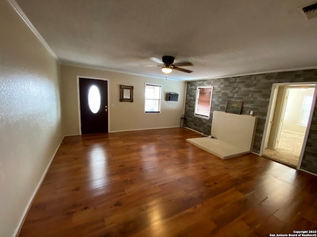 foyer featuring dark hardwood / wood-style floors, ornamental molding, and ceiling fan