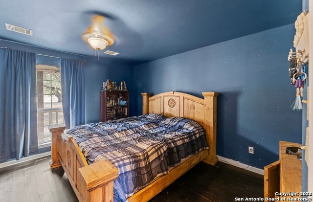 bedroom with dark hardwood / wood-style floors and ceiling fan