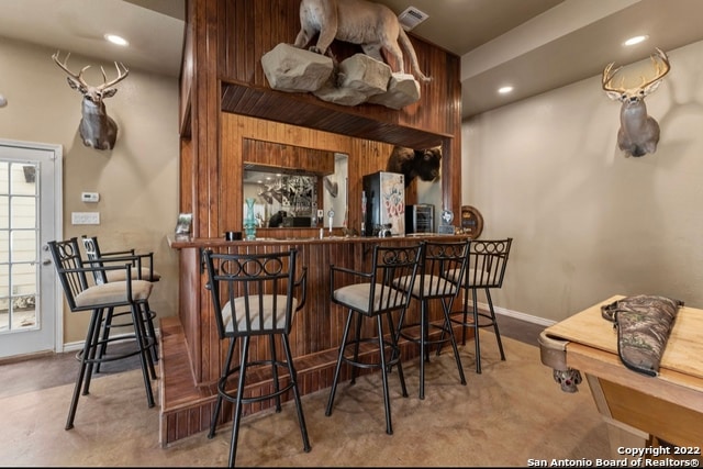 bar featuring wood walls and fridge