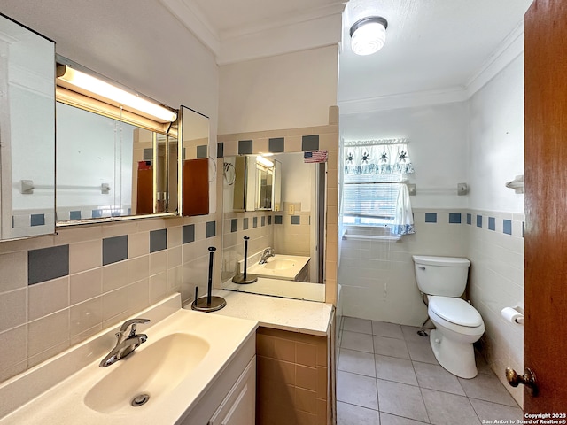 bathroom with vanity, tile patterned floors, tile walls, and crown molding